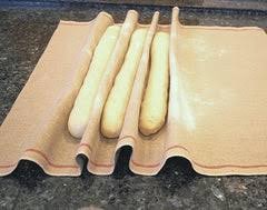 Long bread dough pieces proofing in the folds of a baker's couche