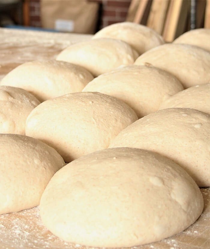 Bench Rest: pre-shaped dough rounds resting uncovered on a bench